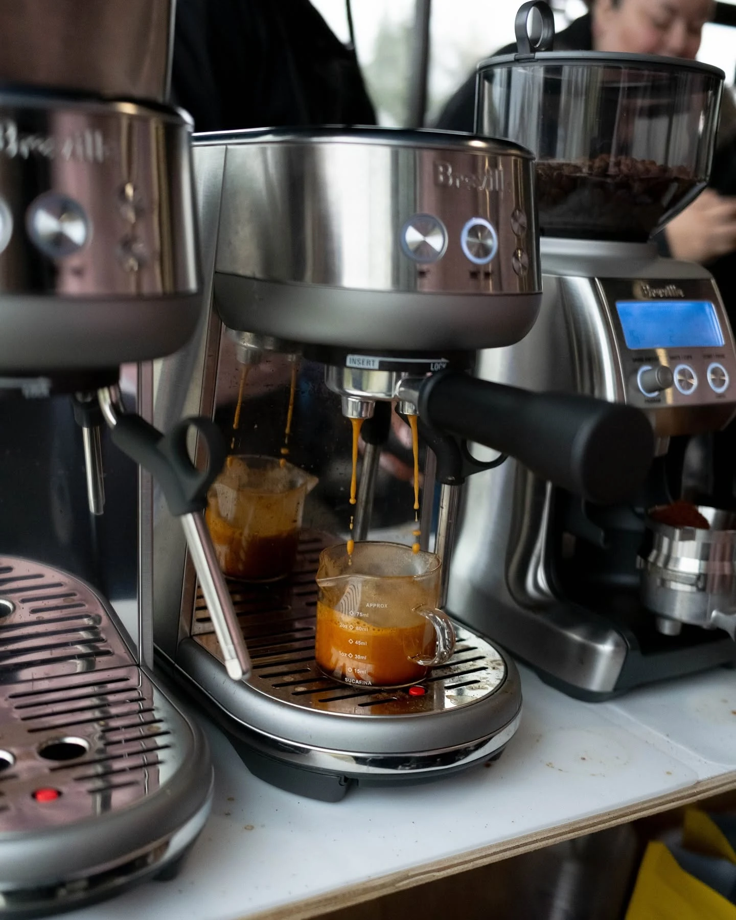 Fresh espresso pouring into a glass at the her coffee cart